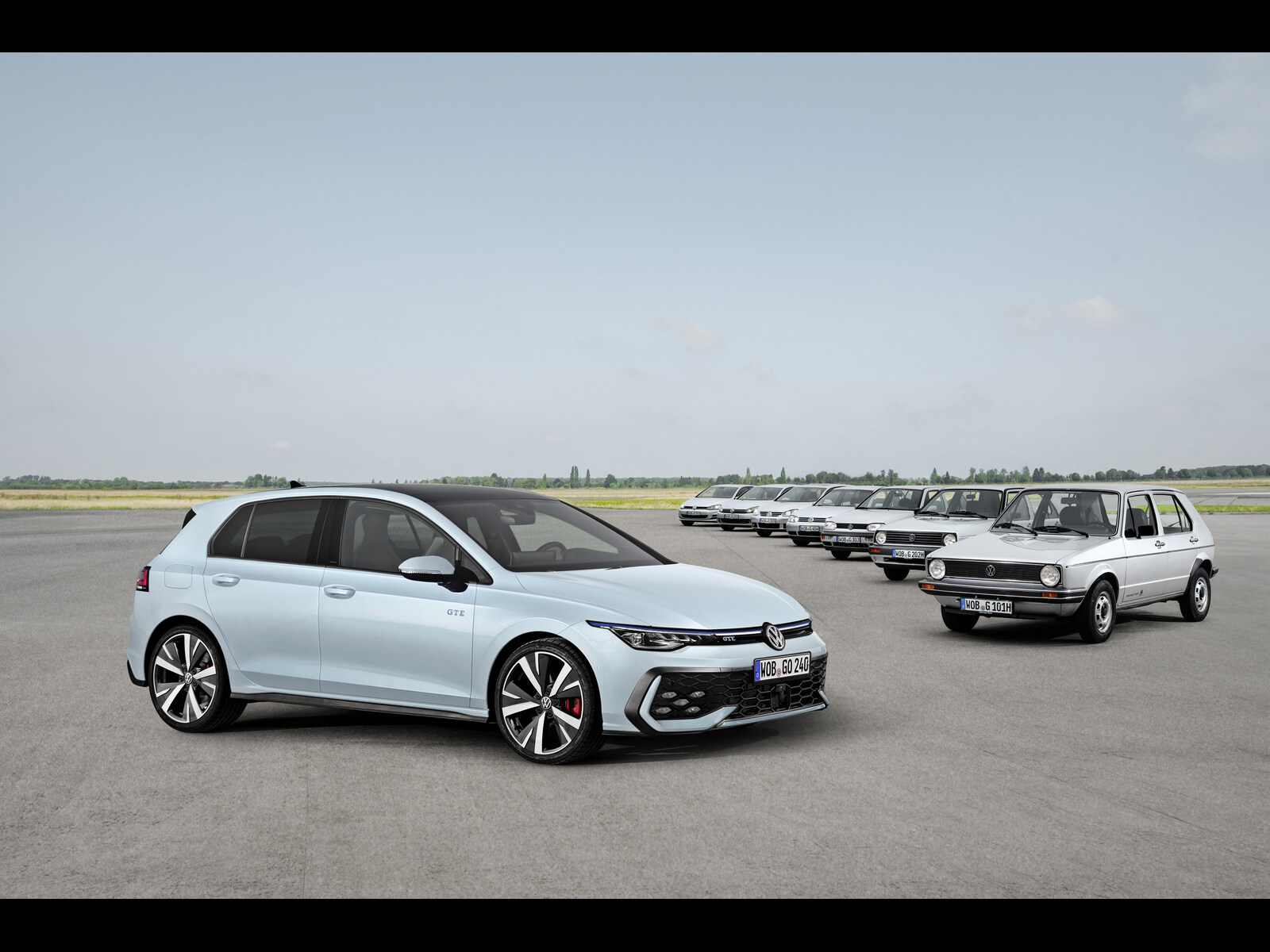 Light teal Volkswagen Golf 8 next to previous Golf generations